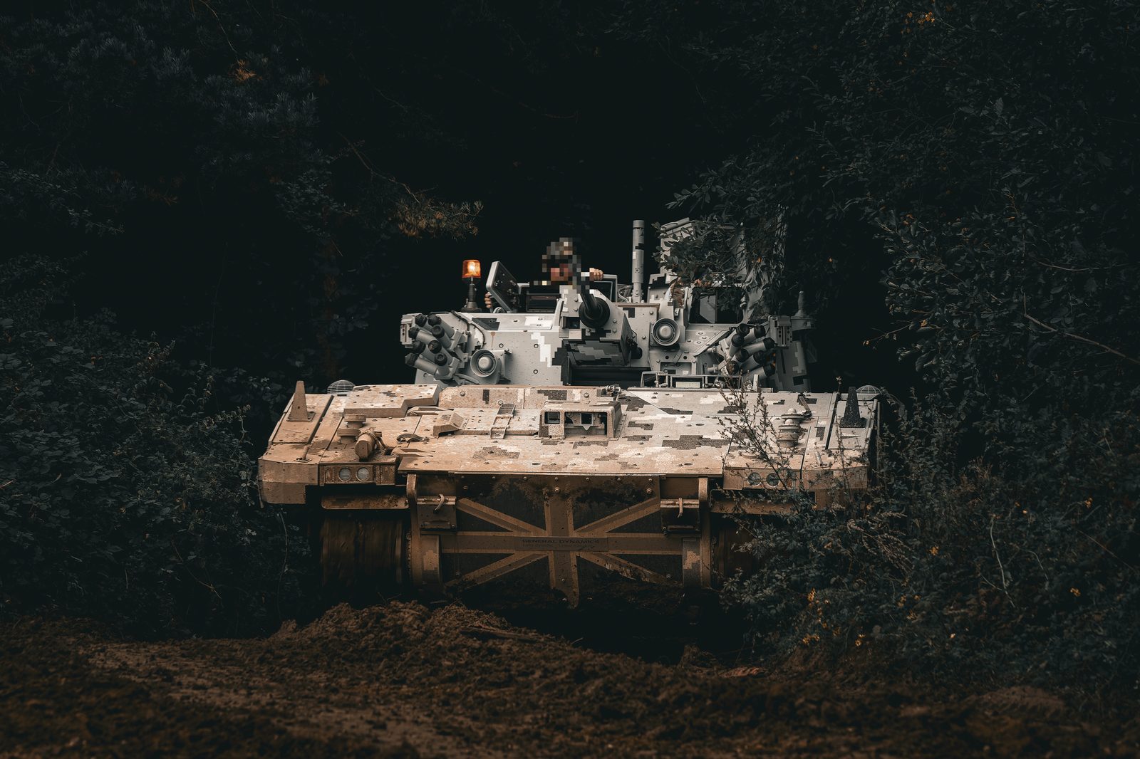 Armoured vehicle emerging from dark woodland