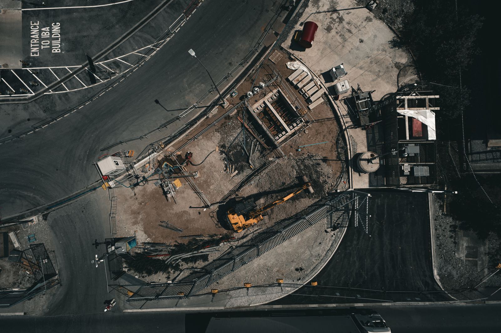 Top-down aerial of a shaft excavation on a live compound