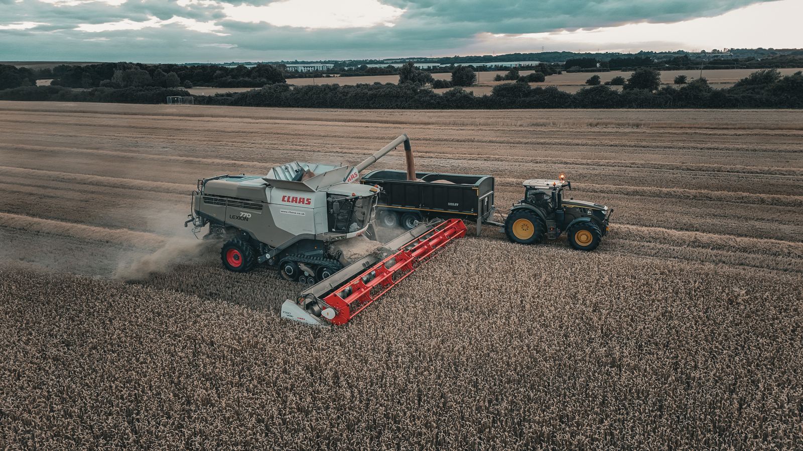 Aerial of a combine and tractor working the harvest